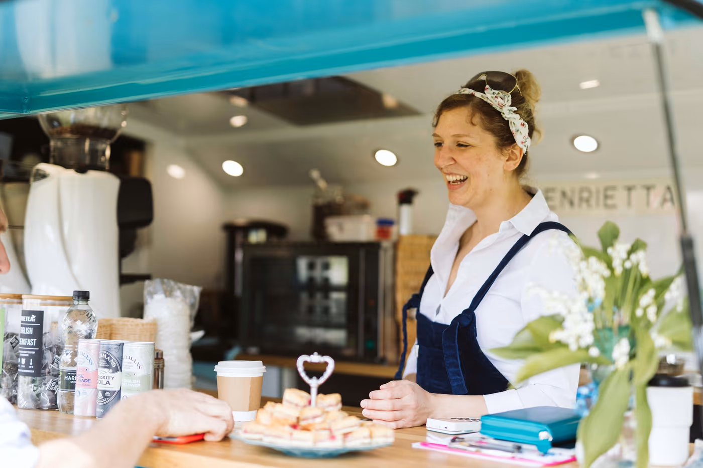 Rosa at the counter inside Henrietta, the 1967 Citroen H van, with the Henrietta sign behind her